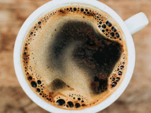 Coffee cup from an aerial view, showing crema bubbling on top.